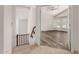 Bright hallway features a wooden railing and doorway leading to a bedroom with vaulted ceilings and a ceiling fan at 9661 E Glencove Cir, Mesa, AZ 85207