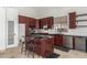Elegant kitchen with dark wood cabinetry, granite countertops, and stainless steel appliances, including a wine cooler at 9661 E Glencove Cir, Mesa, AZ 85207