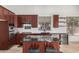 Stylish kitchen featuring dark wood cabinets, granite countertops, and stainless steel appliances for a modern cooking experience at 9661 E Glencove Cir, Mesa, AZ 85207
