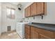Bright laundry room with full size washer and dryer, built in cabinets, and a window at 9661 E Glencove Cir, Mesa, AZ 85207