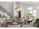Bright, staged living room featuring high ceilings, elegant dining table, and large windows letting in natural light at 9661 E Glencove Cir, Mesa, AZ 85207