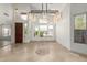 Bright living room with high ceilings, travertine floors, a statement chandelier, and front-facing windows at 9661 E Glencove Cir, Mesa, AZ 85207