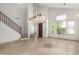 Bright living room featuring travertine floors, a statement chandelier, staircase, and neutral paint at 9661 E Glencove Cir, Mesa, AZ 85207