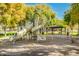 A well-maintained playground featuring slides and a spring rider, set against a backdrop of lush green trees and a gazebo at 9661 E Glencove Cir, Mesa, AZ 85207
