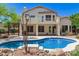 Backyard with a sparkling pool, manicured landscaping, and a second story balcony, offering privacy and relaxation at 9661 E Glencove Cir, Mesa, AZ 85207