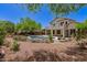 The backyard features a sparkling pool, covered patio, and lush desert landscaping, ideal for outdoor enjoyment at 9661 E Glencove Cir, Mesa, AZ 85207