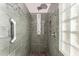 Modern shower with multiple shower heads, glass block window and pebble flooring at 9661 E Glencove Cir, Mesa, AZ 85207