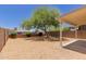 A gravel backyard offers a covered patio area and a mature shade tree at 9717 W Purdue Ave, Peoria, AZ 85345