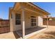 A covered patio offers a shaded area in the gravel backyard, accessible via a secure screen door at 9717 W Purdue Ave, Peoria, AZ 85345
