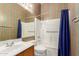 This bathroom features striped wallpaper, a sink, a toilet, and a shower with a bathtub at 9717 W Purdue Ave, Peoria, AZ 85345