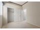 This bedroom features neutral walls, plush carpet, and a spacious closet with sliding doors at 9717 W Purdue Ave, Peoria, AZ 85345