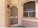 Welcoming front door and window of a well-maintained home, enhanced by an exterior light at 9717 W Purdue Ave, Peoria, AZ 85345