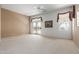Spacious living room featuring neutral carpet, a ceiling fan, and a sliding door to the exterior at 9717 W Purdue Ave, Peoria, AZ 85345