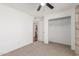 A bright bedroom features neutral carpet, a ceiling fan, and a closet for storage at 9801 N 56Th Dr, Glendale, AZ 85302