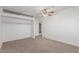 A simple bedroom with neutral carpet, a ceiling fan, and a closet at 9801 N 56Th Dr, Glendale, AZ 85302