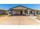 Front view of a house featuring a covered carport and a well-maintained exterior with desert landscaping at 9801 N 56Th Dr, Glendale, AZ 85302