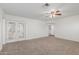 This bright living room features neutral carpeting and french doors for backyard access at 9801 N 56Th Dr, Glendale, AZ 85302