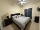 Cozy bedroom featuring ceiling fan, TV, and a queen-sized bed with a gray comforter at 1038 S Palomino Creek Dr, Gilbert, AZ 85296