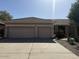 Front exterior of home with three-car garage and manicured landscaping at 1038 S Palomino Creek Dr, Gilbert, AZ 85296