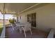 Cozy, covered back patio with a table and chairs, adjacent to a well-maintained yard at 10702 W Salem Dr, Sun City, AZ 85351