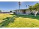 A quaint covered patio and a neatly landscaped yard with mature trees at 10702 W Salem Dr, Sun City, AZ 85351