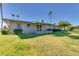 Spacious backyard with lush green grass, mature trees, and a covered patio, perfect for outdoor living at 10702 W Salem Dr, Sun City, AZ 85351