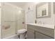 Bathroom featuring grey vanity, shower over tub with textured glass door, and neutral finishes at 10702 W Salem Dr, Sun City, AZ 85351
