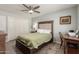 Bedroom with a tufted headboard bed, ceiling fan, wood-look tile, and a writing desk at 10702 W Salem Dr, Sun City, AZ 85351