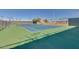 Well-maintained tennis court ready for a match with palm trees nearby at 10702 W Salem Dr, Sun City, AZ 85351