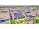 Aerial view of a home with solar panels, landscaped backyard with covered patio, and desert landscaping with many nearby houses at 10715 E Thornton Ave, Mesa, AZ 85212