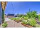 Nicely landscaped backyard featuring a garden, manicured lawn, gravel, a covered patio, and a string of decorative lights at 10715 E Thornton Ave, Mesa, AZ 85212