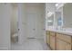 Bright bathroom featuring double vanity, white countertops, and a separate toilet room at 10715 E Thornton Ave, Mesa, AZ 85212