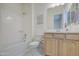 Bright bathroom featuring a light wood vanity, bath, and shower at 10715 E Thornton Ave, Mesa, AZ 85212