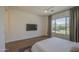 Spacious bedroom featuring a large window, mounted TV, and modern ceiling fan at 10715 E Thornton Ave, Mesa, AZ 85212