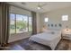 Relaxing bedroom with ceiling fan, large window, and neutral colored rug at 10715 E Thornton Ave, Mesa, AZ 85212