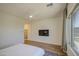 Bedroom with ceiling fan, attached TV and large window with blackout shades at 10715 E Thornton Ave, Mesa, AZ 85212