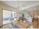 Open dining room with hardwood floors leading to kitchen and patio seating area at 10715 E Thornton Ave, Mesa, AZ 85212