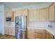 Well-lit kitchen featuring stainless steel refrigerator, modern microwave, and abundant counter space at 10715 E Thornton Ave, Mesa, AZ 85212