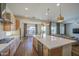 Open-concept kitchen with island seating and stainless steel appliances opening to dining and living area at 10715 E Thornton Ave, Mesa, AZ 85212