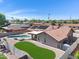 Beautiful backyard featuring a pool, synthetic grass area, and a covered patio perfect for outdoor living at 1231 E Sunburst Ln, Tempe, AZ 85284