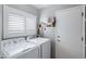 Functional laundry room with washer, dryer, storage shelves and lots of natural light at 1231 E Sunburst Ln, Tempe, AZ 85284