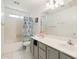 Neutral toned bathroom includes a double sink vanity and a tub shower with a colorful curtain at 1254 W Browning Way, Chandler, AZ 85286