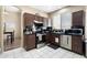 Cozy kitchen featuring stainless steel appliances, dark cabinetry, and tile flooring at 1254 W Browning Way, Chandler, AZ 85286