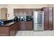 Kitchen with stainless steel refrigerator, dark cabinets and tile countertops at 1254 W Browning Way, Chandler, AZ 85286
