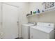 Clean laundry room with washer, dryer, and storage shelves at 1254 W Browning Way, Chandler, AZ 85286