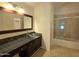 Bright bathroom featuring a glass bowl sink, dark cabinetry, and a shower with glass doors at 1309 W Calle Del Norte --, Chandler, AZ 85224
