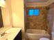 Bathroom featuring white tub with tiled walls and an undermount sink with dark wood cabinets at 1309 W Calle Del Norte --, Chandler, AZ 85224