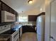 Functional kitchen with granite countertops, dark cabinets, stainless steel appliances, and a bright window at 1309 W Calle Del Norte --, Chandler, AZ 85224