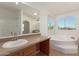 Bright bathroom featuring a soaking tub, shower, vanity with mirror, and a window with an outdoor view at 13217 S Tuthill Rd, Buckeye, AZ 85326