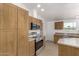 Kitchen features wood cabinetry and stainless appliances including microwave, oven, and dishwasher at 13217 S Tuthill Rd, Buckeye, AZ 85326